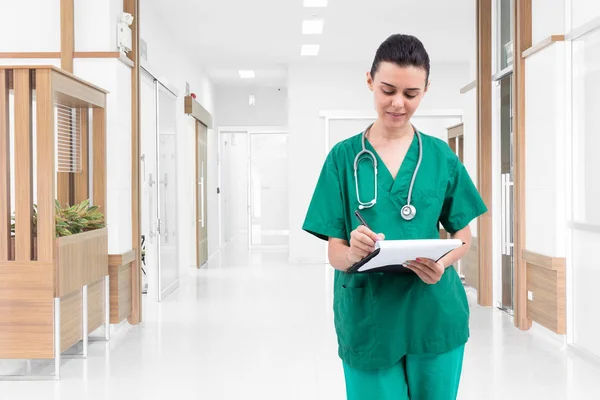 Enfermeira a escrever um registo médico no corredor do hospital — Fotografia de Stock