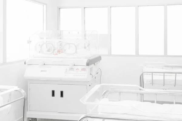 Newborn baby covered inside incubator in hospital post-delivery room