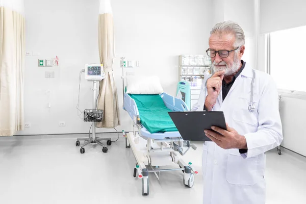 Médico sênior foi examinar um registro médico no quarto do hospital — Fotografia de Stock