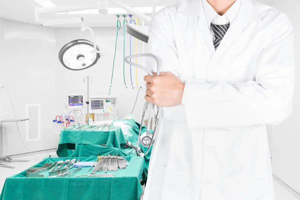 医生用听诊器构成双臂交叉与手术室在背景 — 图库照片