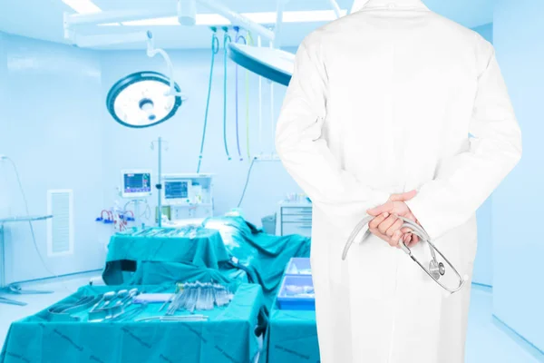 Close-up rear view image of doctors with stethoscope pose arms crossed behind back looking at medical equipment in a surgical room of modern hospital — Stock Photo, Image