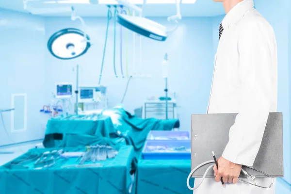 Doctor holding clipboard with stethoscope with an operating room — Stock Photo, Image