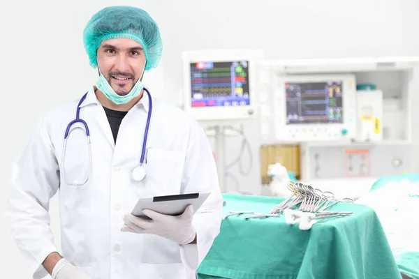 Young doctor using tablet computer in operating room — Stock Photo, Image