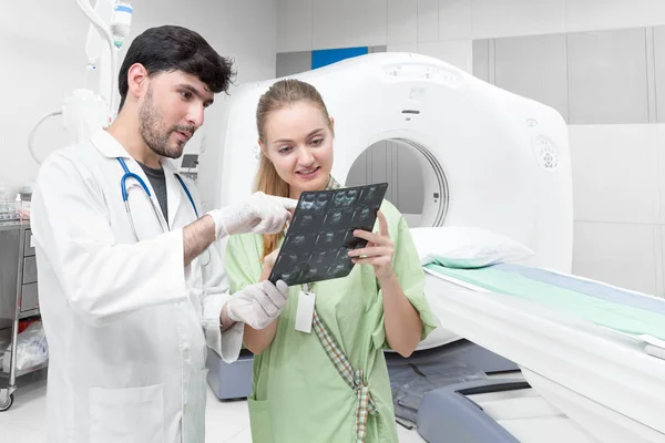 Médico na sala de tomografia examinando um raio-x e discutindo — Fotografia de Stock