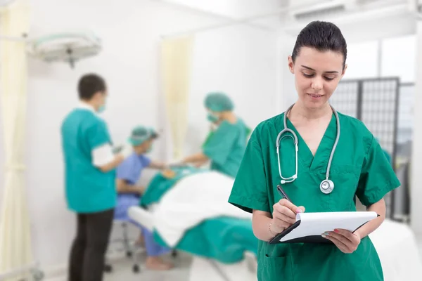 Enfermeira escrevendo prontuário na sala de cirurgia — Fotografia de Stock