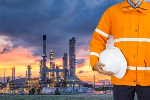 Ingeniero de la industria petrolera que usa abrigo de seguridad y sostiene casco de seguridad — Foto de Stock