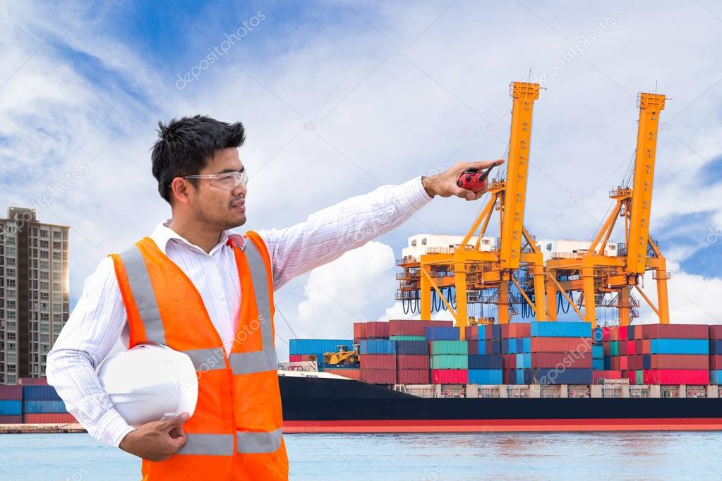 Port engineer standing in front of the industrial harbor with co