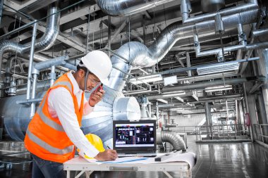 Elektrik mühendisi modern bir termal kontrol odasında çalışma 