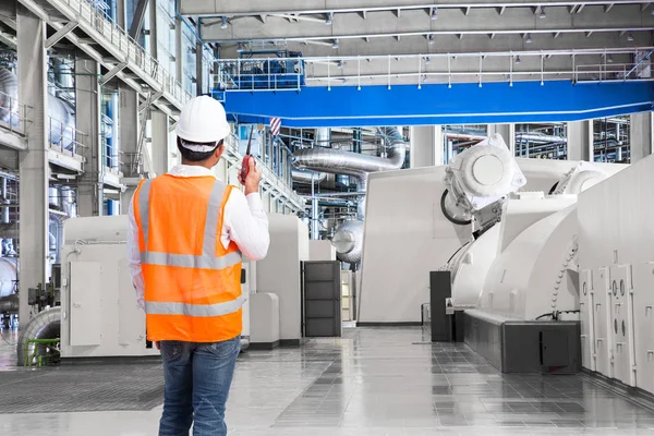 Engineer working in a thermal power plant with talking on the wa