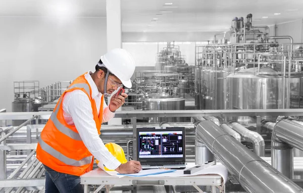 Ingeniero industrial comprobando el estado de la máquina con computadora portátil — Foto de Stock