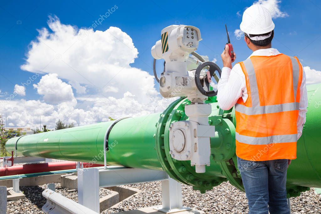 Engineer talking on the walkie-talkie for controlling pipeline v
