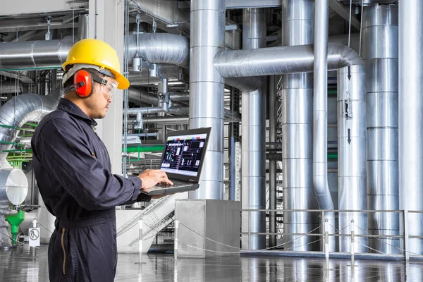 Engenheiro usando computador portátil para manutenção de equipamentos powerhouse — Fotografia de Stock