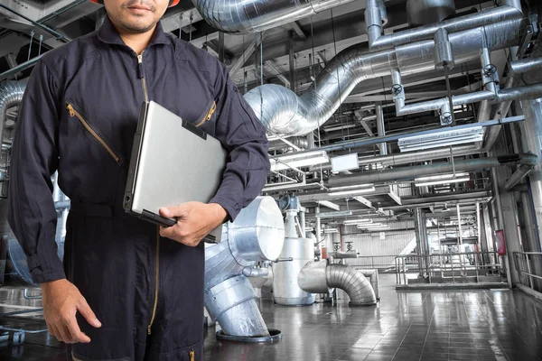 Engineer using laptop computer in the factory