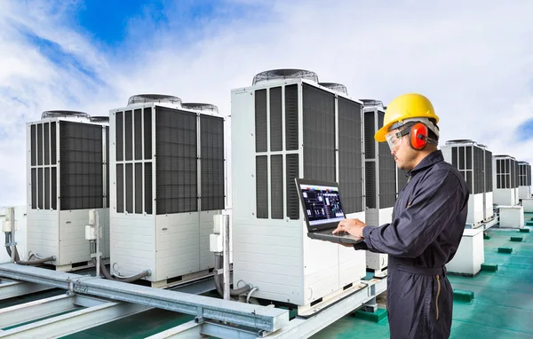 Ingeniero eléctrico que utiliza el ordenador portátil para el mantenimiento del sistema de aire acondicionado en la azotea de fábrica — Foto de Stock