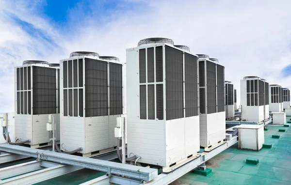 Una fila de unidades de aire acondicionado en la azotea con cielo azul — Foto de Stock