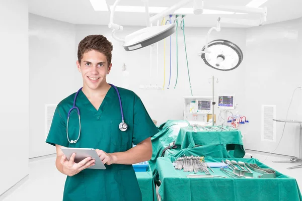 Sonriente médico joven usando tableta en la habitación del hospital —  Fotos de Stock