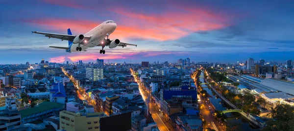 Flugzeug hebt in der Dämmerung über der Panoramastadt ab — Stockfoto