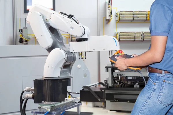 Ingeniero que controla la robótica automatizada para sostener el tablero electrónico del montaje en la fábrica elegante, concepto de la industria 4.0 — Foto de Stock