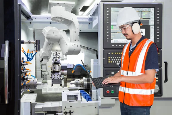 Mühendis ile Cnc makine akıllı fabrikada bakım otomatik robot kol için dizüstü bilgisayar kullanarak. Sanayi 4.0 konsept