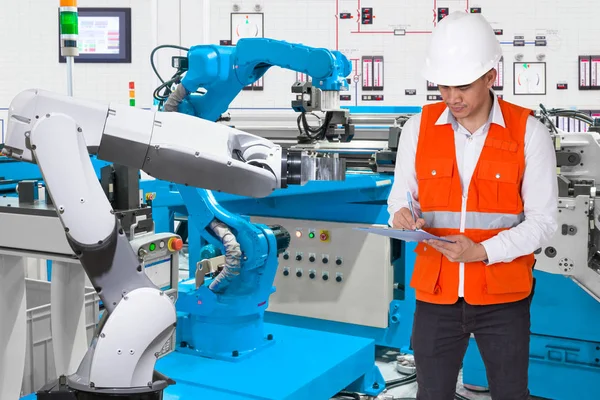 Ingeniero verificando mantenimiento diario de robótica automatizada en línea de producción, concepto Industria 4.0 — Foto de Stock