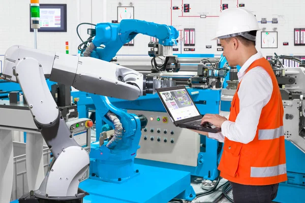 Engineer using laptop computer for maintenance automatic robotic hand machine tool at industrial manufacture factory, Industry 4.0 concept — Stock Photo, Image