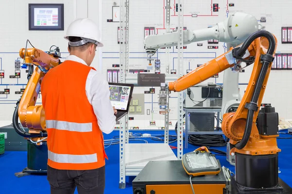 Інженер встановлює і тестує промисловість роботів у виробництві заводу — стокове фото