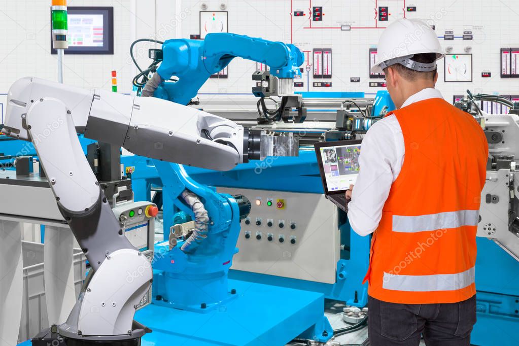 Engineer using laptop computer for maintenance automatic robotic hand machine tool at industrial manufacture factory, Industry 4.0 concept