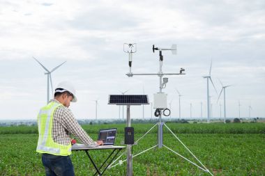 Engineer using tablet computer collect data with meteorological instrument to measure the wind speed, temperature and humidity and solar cell system on corn field background, Smart agriculture technology concept clipart