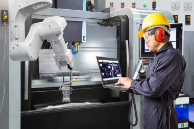 Bakım mühendisi ile Cnc makine akıllı fabrikada dizüstü bilgisayar kontrol otomatik robot el kullanarak. Sanayi 4.0 konsept