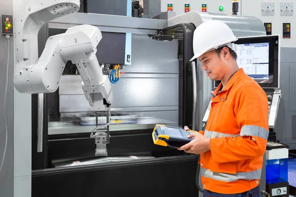 Wartungsingenieur programmiert automatische Roboterhand mit CNC-Maschine in Smart Factory. Konzept Industrie 4.0 — Stockfoto