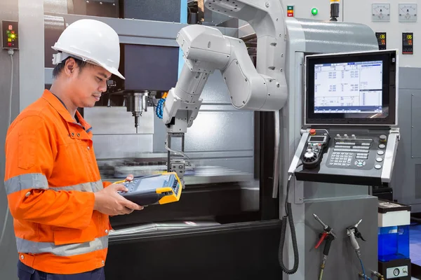 Wartungsingenieur programmiert automatische Roboterhand mit CNC-Maschine in Smart Factory. Konzept Industrie 4.0 — Stockfoto