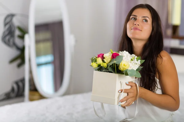 Mulher com uma linda caixa de chapéu com flores — Fotografia de Stock