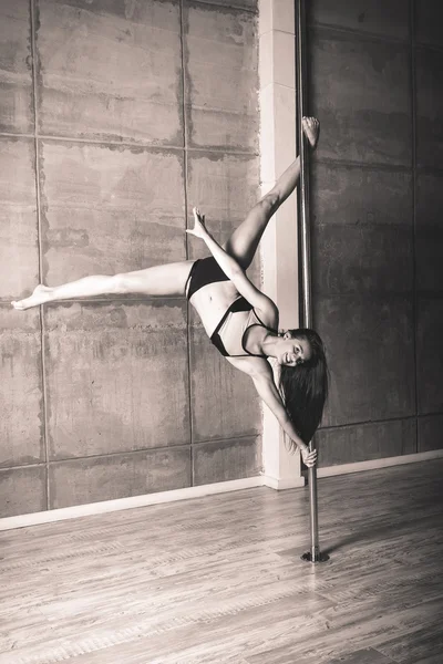 Όμορφη νεαρή γυναίκα που εκτελεί pole dance στοιχεία — Φωτογραφία Αρχείου