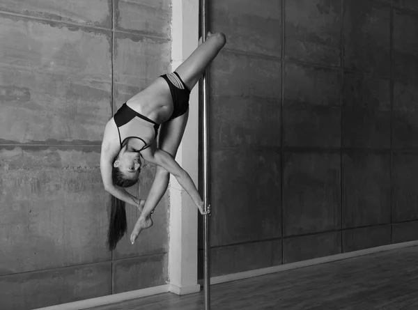 Beautiful young woman performing pole dance elements — Stock Photo, Image