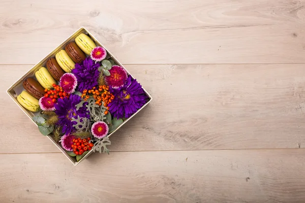 Vak met bloemen en macaroon cookies — Stockfoto