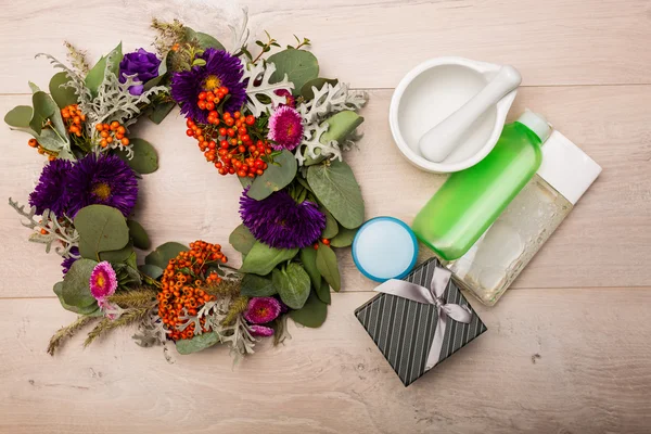 Seizoensgebonden skincare producten met bloemen op een houten achtergrond — Stockfoto