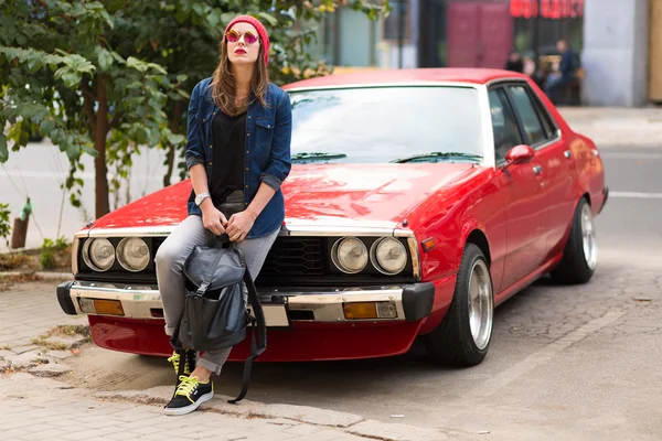 Pretty stylish woman standing by the retro car — Stockfoto