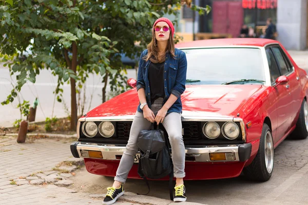 Ziemlich stylische Frau steht neben dem Retro-Auto — Stockfoto