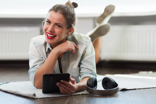 Mujer bastante joven leyendo un libro electrónico — Foto de Stock