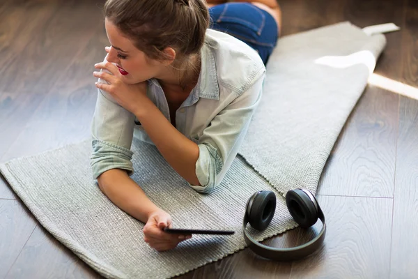 Pretty young woman reading an e-book — Stock Photo, Image