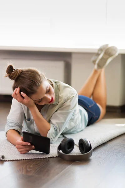 Pretty young woman reading an e-book Royalty Free Stock Photos