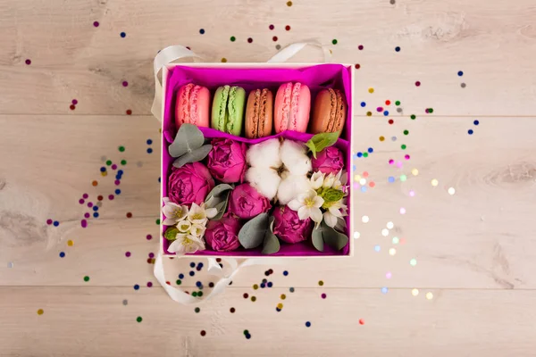 Цветы в подарочной коробке и красочные конфетти — стоковое фото