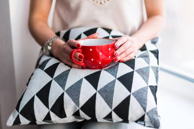 Elinde kahve tutan bir kadın.