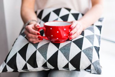 Elinde kahve tutan bir kadın.