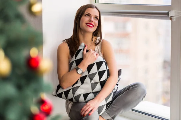 Beautiful woman sitting by the window — Stock Photo, Image