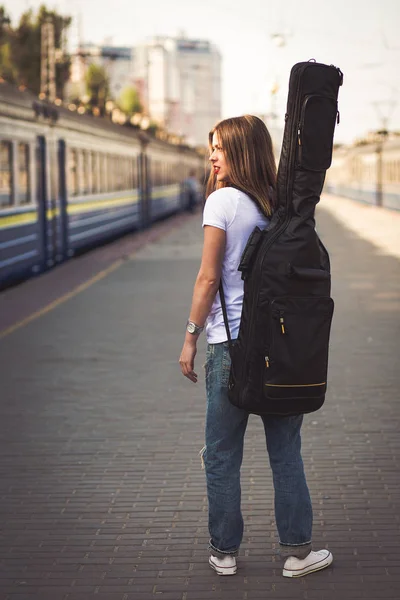 Kobieta z gitara na stacji kolejowej — Zdjęcie stockowe