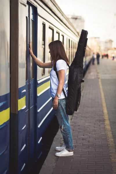 Mulher com guitarra na estação ferroviária — Fotografia de Stock