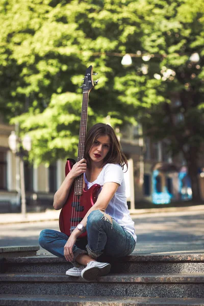 Woman with guitar in the city — Stock Photo, Image