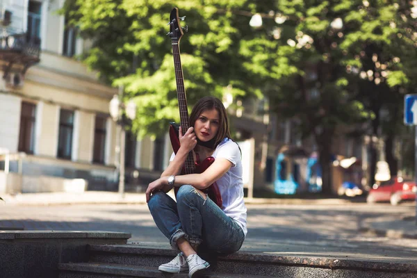 Kobieta z gitara w mieście — Zdjęcie stockowe
