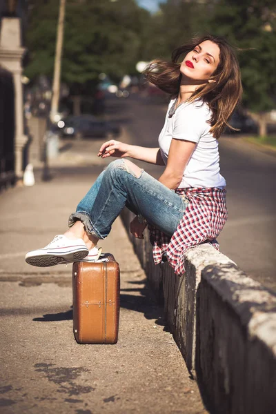 Женщина с чемоданом в городе — стоковое фото